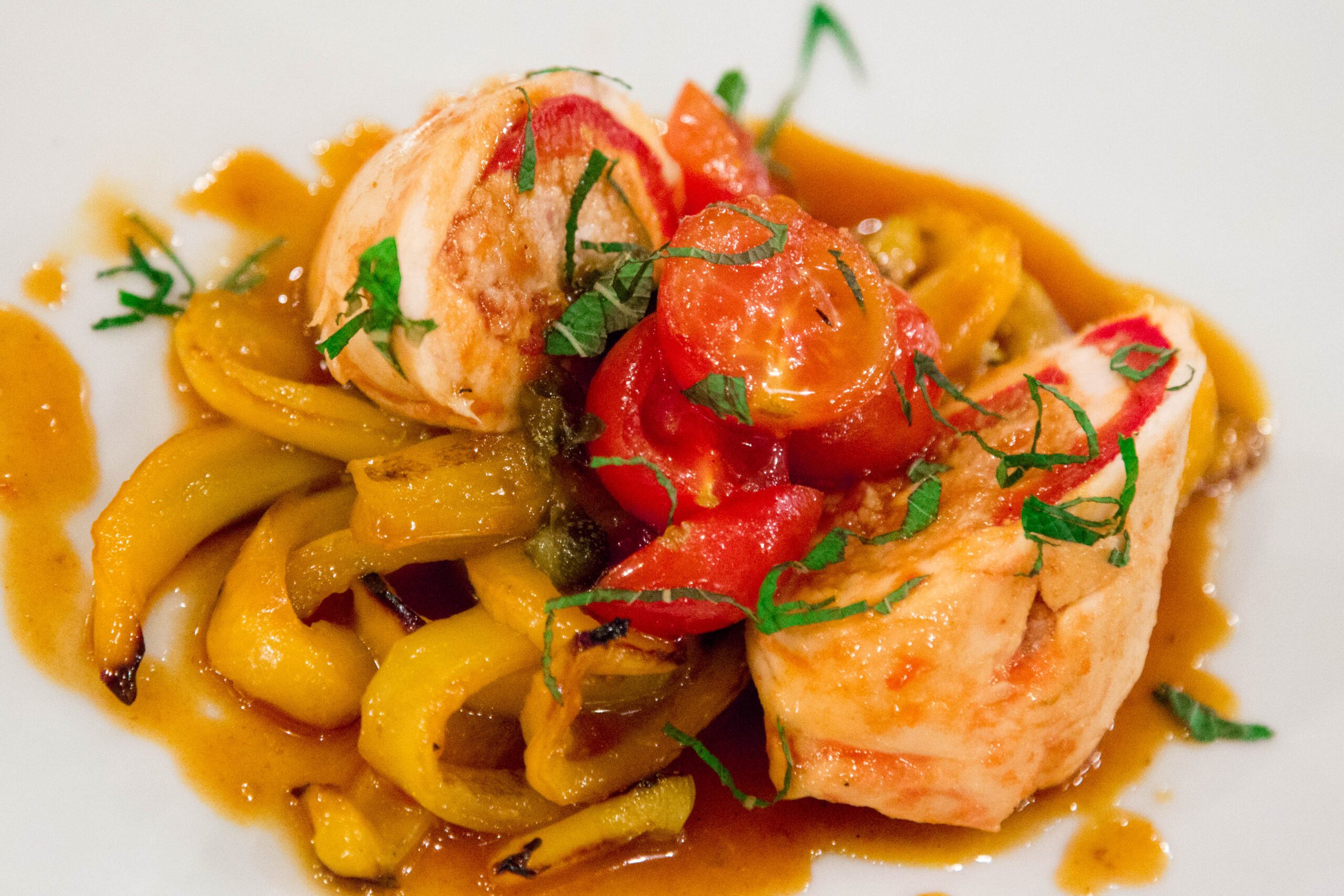 Piatto di pollo, peperoni e pomodori della cucina di Il Locale